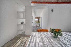 A room with a checkered table, a wooden bench, and a potted plant.