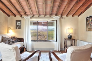 A cozy room with a large window, a wooden ceiling, and a view of the countryside. - Country House Nazzano in Vineyards/Olive Grove near San Gimignano Florence Siena (Gambassi Terme)