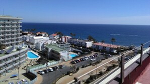 Un hôtel situé sur la côte, composé de plusieurs bâtiments, doté d’une piscine et d’un parking.