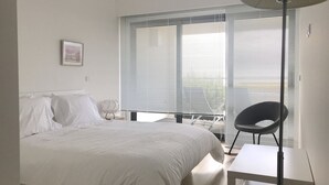 Ein schlicht eingerichtetes Schlafzimmer mit Bett, Schreibtisch und Stuhl.