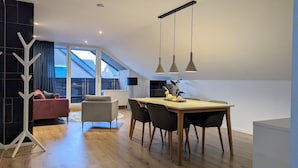 Eine moderne Wohnung mit Essbereich, einer Sitzecke und Blick ins Freie.