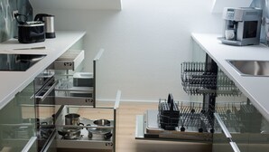 Eine moderne Küche mit integrierten Geräten, einer Kaffeemaschine und einem Besteckhalter.