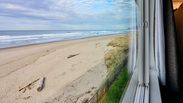 Vista a la playa desde una ventana con vistas al océano y la costa.