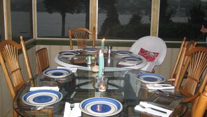 A dining table set for six with blue and white plates, surrounded by wooden chairs.