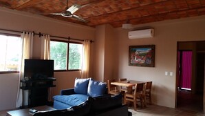 A living room with a sofa, TV, and dining table.