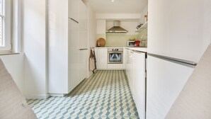 A compact kitchen with white cabinets, a microwave, and a stove.