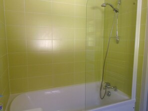 Een bad, een haardroger, handdoeken, toiletpapier