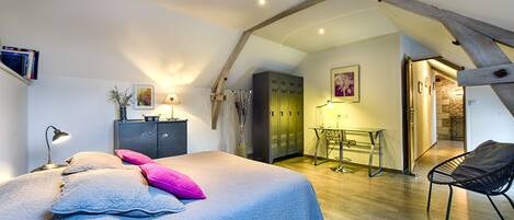 A bedroom with a bed, a desk, and a chair.