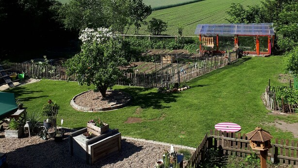 A garden with a wooden gazebo, a fenced area, and a tree. - Holiday in the Elbe Weser triangle on a Resthof near the North Sea (Hipstedt)