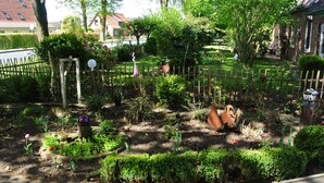 A well-maintained garden with various plants and a wooden fence. - Holiday in the Elbe Weser triangle on a Resthof near the North Sea (Hipstedt)