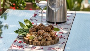 A table with a bottle of wine, two glasses, and a plate of walnuts by a poolside. - Villa near Trogir - private beach, bbq, parking, turqouise sea, boat rental :) (Rogoznica)