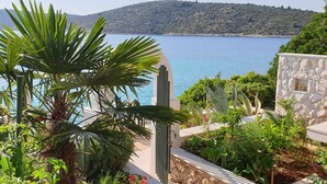 A coastal view with a stone building, lush greenery, and a clear blue sea. - Villa near Trogir - private beach, bbq, parking, turqouise sea, boat rental :) (Rogoznica)