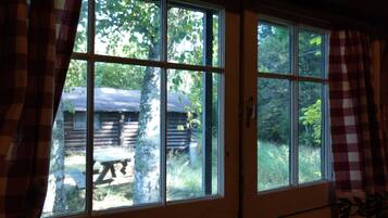 A cabin with a large window overlooking a forest.