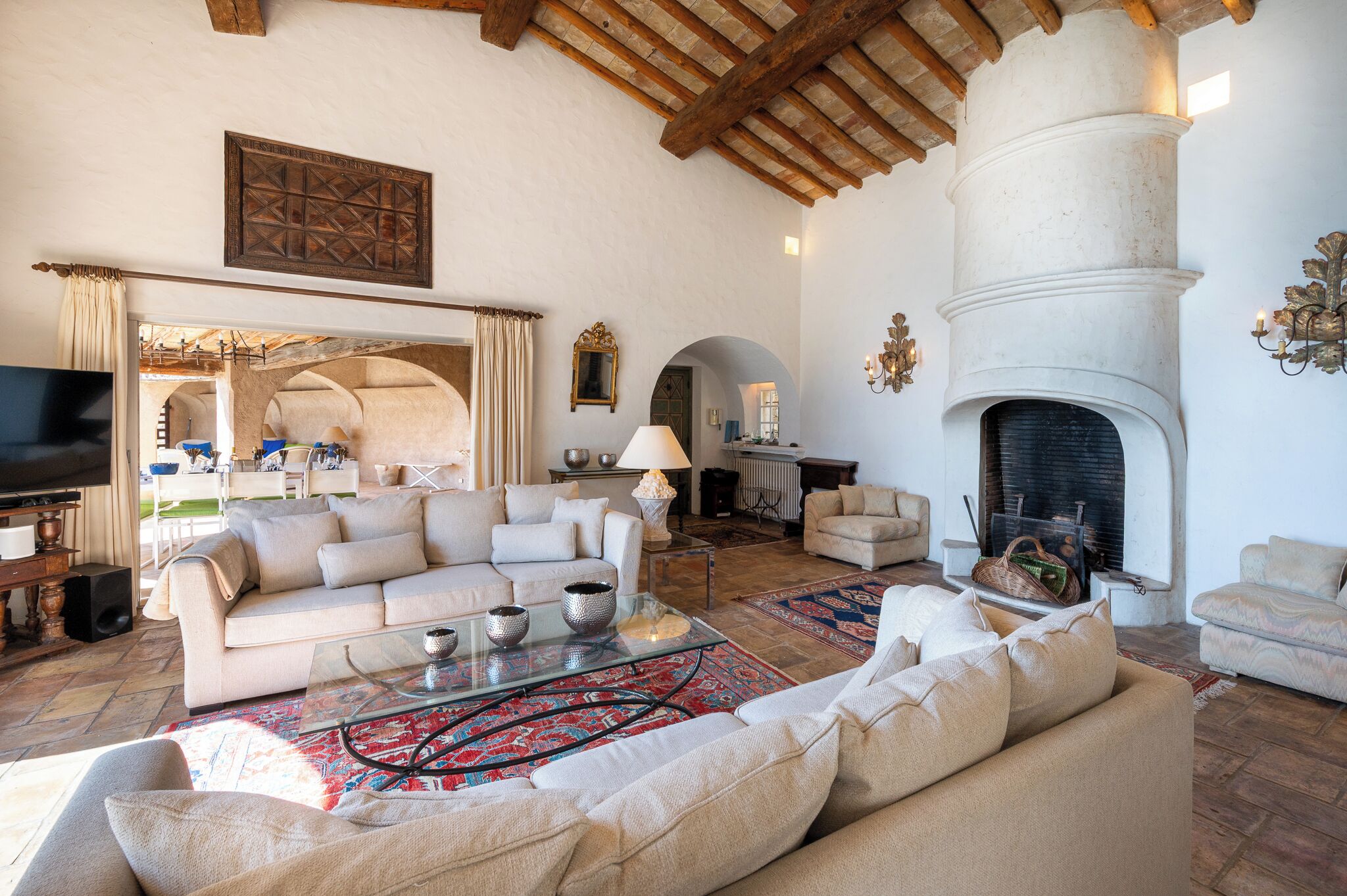 A spacious living room with a fireplace, sofas, and a television.
