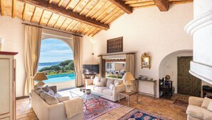 A spacious living room with a large window, a sofa, a TV, and a pool view. - Villa panoramic sea view gulf of Saint -Tropez swimming pool 6 bedrooms 6 bathrooms 12 pers (Sainte-Maxime)