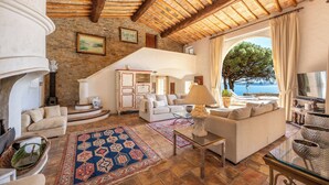 A spacious living room with a fireplace, sofas, a coffee table, and a view of the sea. - Villa panoramic sea view gulf of Saint -Tropez swimming pool 6 bedrooms 6 bathrooms 12 pers (Sainte-Maxime)