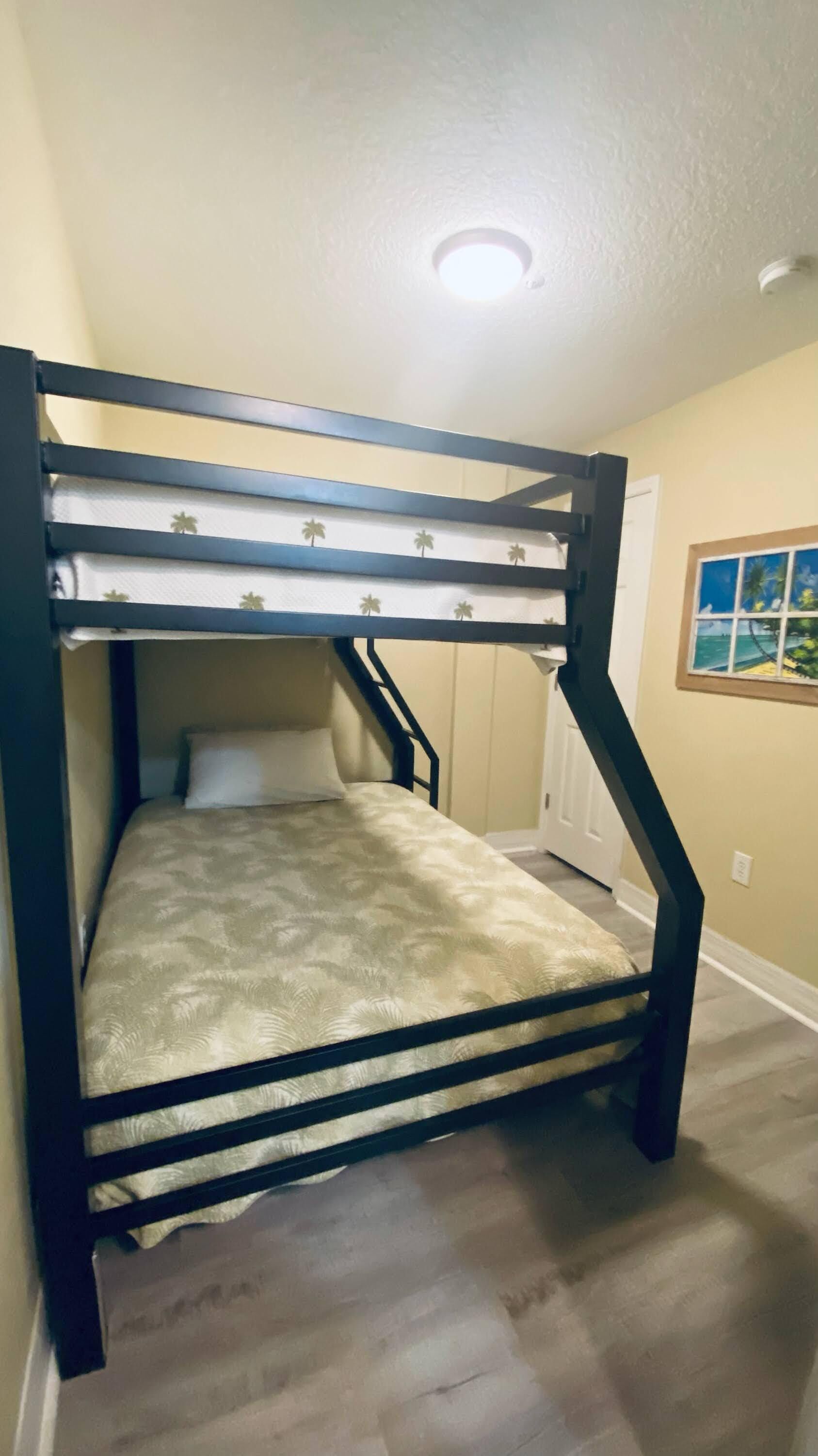 A bunk bed with a headboard and a window with a view of the outdoors.