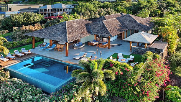 Ein luxuriöses Resort mit mehreren Bungalows über dem Wasser, einem Schwimmbad und üppiger tropischer Bepflanzung.