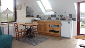 A compact kitchen with a dining area, a small refrigerator, and a skylight. - Gouelet-Ker "Ouessant" (LOGONNA DAOULAS)