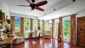 A spacious room with a ceiling fan, a dining table with chairs, and a large window with curtains. - STUNNING LUXURY ESTATE IN THE EXCLUSIVE MESA AREA OF PALM SPRINGS (Palm Springs)