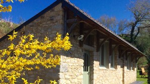 A stone building with a green door, wooden beams, and a stone wall. - "In the Land of Abers", in a valley of mills, 800m from the Aber (beaches 9 ') (Plouguin)
