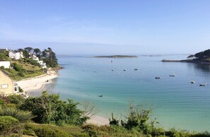 A coastal view with clear waters, boats, and a sandy beach. - "In the Land of Abers", in a valley of mills, 800m from the Aber (beaches 9 ') (Plouguin)