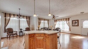 A spacious kitchen with a central island, wooden cabinets, and pendant lighting. - Yellowstone Mountain View  (Gardiner)