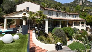 Une villa de style méditerranéen dotée d’un vaste patio, d’un espace extérieur aménagé et couvert, et d’un jardin bien entretenu.