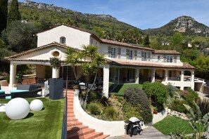 A Mediterranean-style villa with a spacious patio, a covered outdoor seating area, and a well-maintained garden.