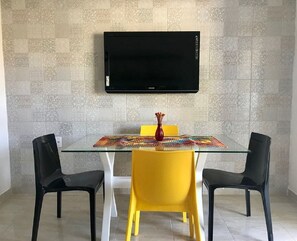 Enjoy meals in this stylish dining area with a glass-top table, comfortable seating, and a flat-screen TV.
