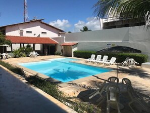 Relax by the pool surrounded by comfortable lounge chairs and a scenic view.