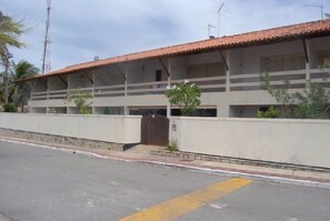 Two-story building with a flat roof and open-air balconies.