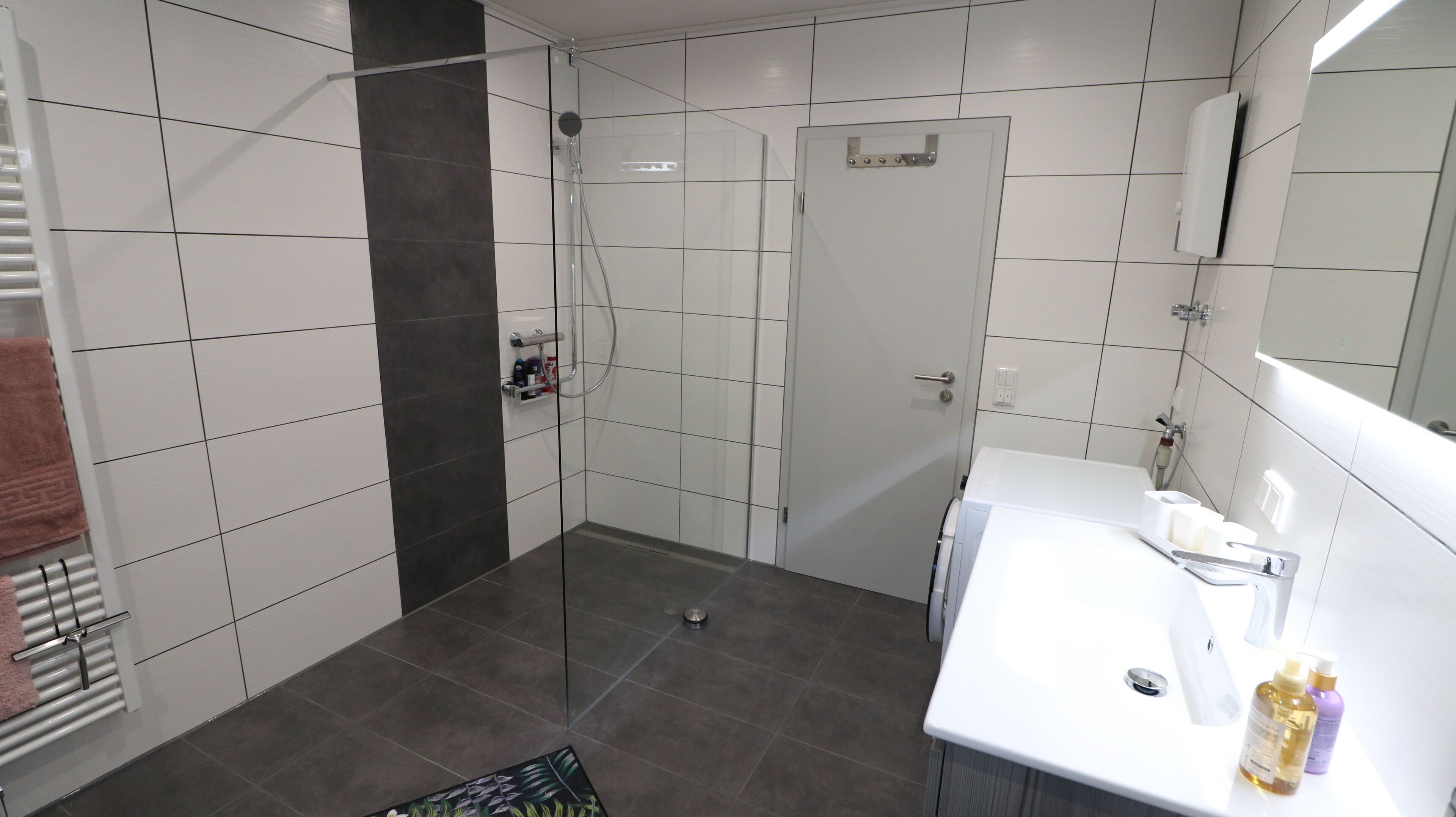 A modern bathroom with a shower, toilet, and sink.
