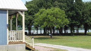 A small building with a porch, a paved path, and a lake in the background.