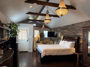 A bedroom with a bed, a TV, a wooden ceiling, and a plant. - Lakefront Escape on 14+ Private Acres | Fish, Swim & Relax (Little Elm)