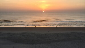 A beach with a sunset in the background.