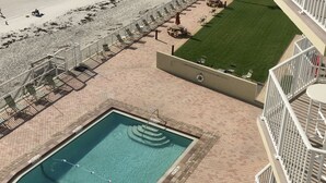 A pool area with a view of the beach and ocean.