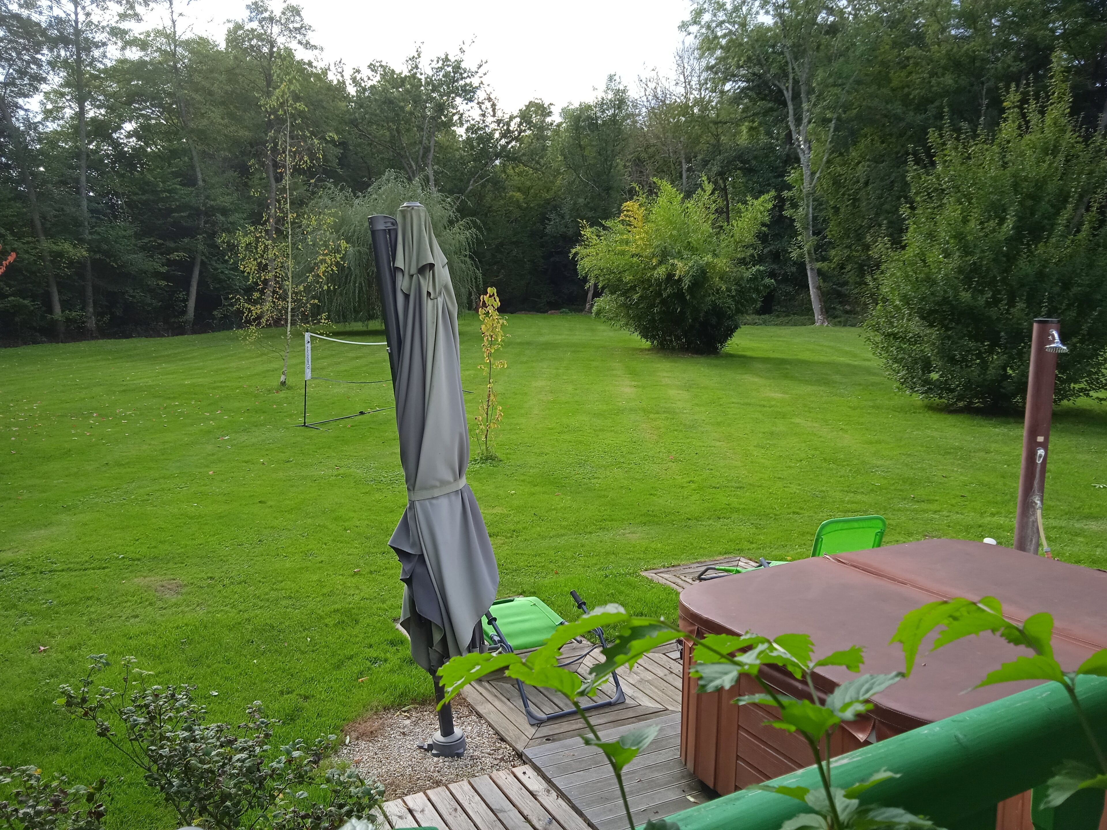 Un patio con mesa, sillas y una sombrilla.
