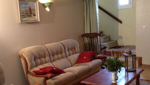 Een woonkamer met een bank, fauteuils, een salontafel en een vloerkleed.