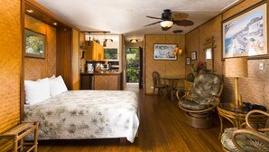 A room with a bed, a dining area, and a kitchen.