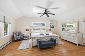 A bedroom with a bed, a ceiling fan, a dresser, a chair, and a nightstand. - Point Pleasant: 082-H Heated Pool, Walk to Beach, Close to everything in Harwich! (West Harwich)