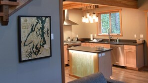A modern interior with a staircase, a kitchen area, and a seating area. - Romantic island retreat  surrounded by majestic trees (Shelton)