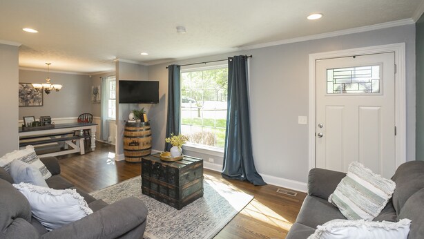 A living room with a sofa, a coffee table, and a television.