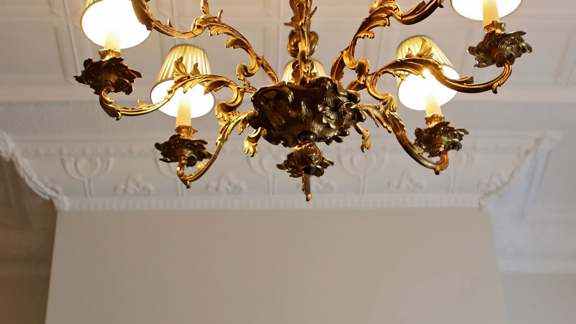 Un candelabro con múltiples lámparas y diseños ornamentales.