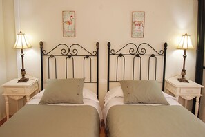 A double bed with a metal headboard, two bedside tables with lamps, and two wall decorations. - Casa Bonita, an authentic Andalusian village experience. Pets-hispeed WIFI-airco (Comares)