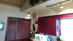 Cozinha com armários de madeira, micro-ondas e decoração de peixe na parede.