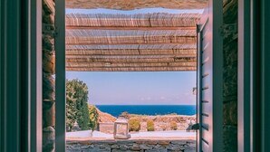 A stone wall leading to a covered outdoor area with a view of the sea.