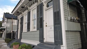A building with a white facade, dark shutters, and a green awning. - Prime Location just steps from the French Quarter & 3 Blocks to Bourbon St, (New Orleans)