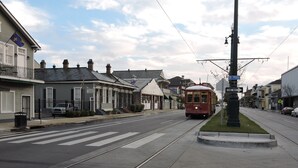 A streetcar on tracks with buildings on either side, a pedestrian crossing, and a street sign for St. Philip. - Prime Location just steps from the French Quarter & 3 Blocks to Bourbon St, (New Orleans)