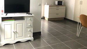 A modern kitchen with a flat-screen TV on a cabinet, a microwave, and a chair. - T2 any comfort in house of village (Grossa)